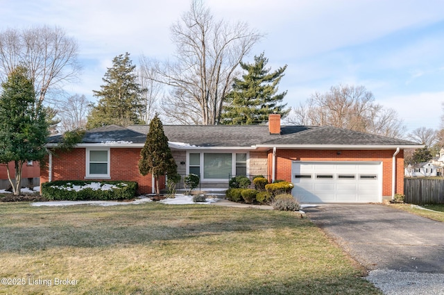 single story home with a garage, a chimney, aphalt driveway, a front yard, and brick siding