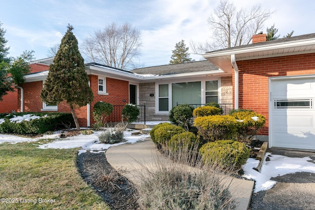 single story home featuring a garage, stone siding, a chimney, and brick siding