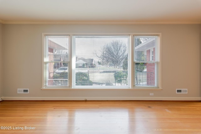 unfurnished room with ornamental molding, plenty of natural light, and visible vents