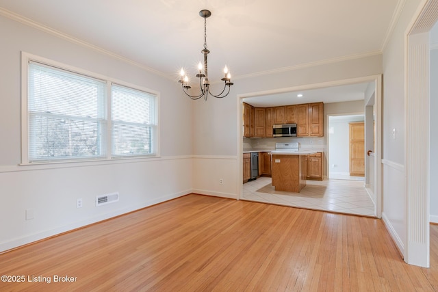 interior space featuring light wood-style flooring, a notable chandelier, visible vents, baseboards, and crown molding