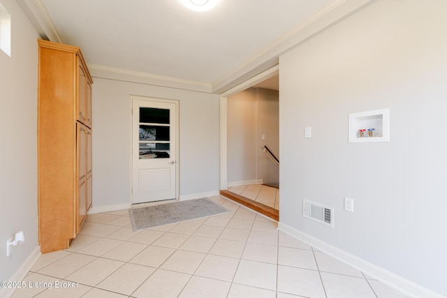 entryway featuring light tile patterned floors, visible vents, ornamental molding, and baseboards