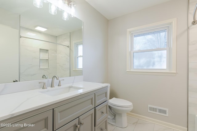 bathroom featuring visible vents, toilet, vanity, baseboards, and walk in shower