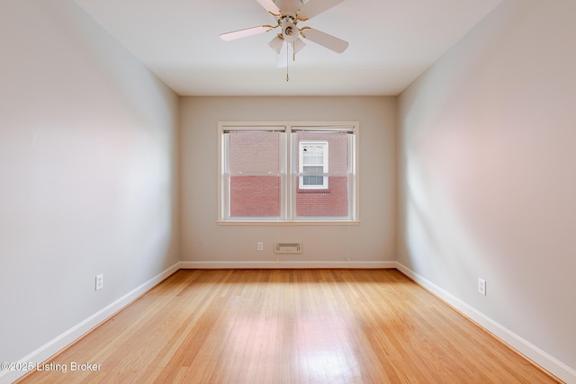 empty room with a ceiling fan, baseboards, and wood finished floors