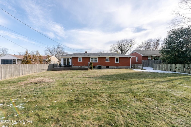 rear view of property featuring fence private yard, a lawn, and a deck