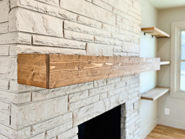 details with a fireplace, wood finished floors, and baseboards