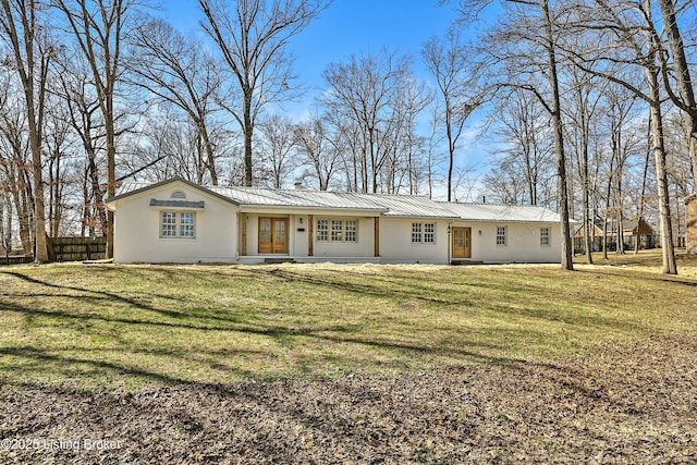 ranch-style house featuring metal roof, a front lawn, and fence