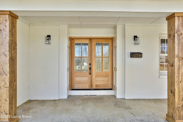 entrance to property featuring brick siding and french doors