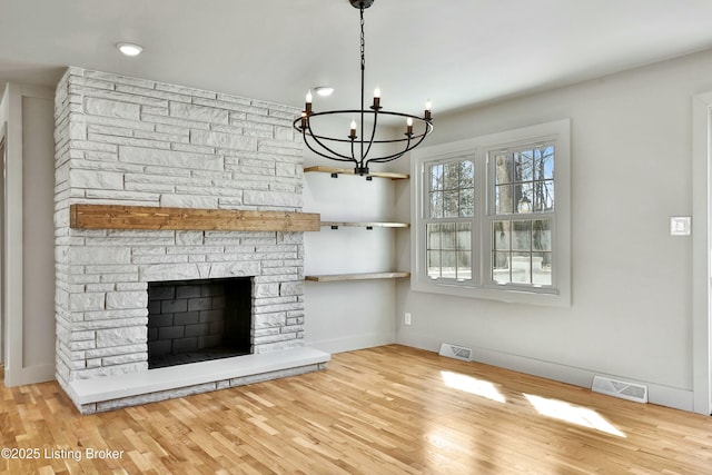 unfurnished living room featuring baseboards, a fireplace, visible vents, and wood finished floors