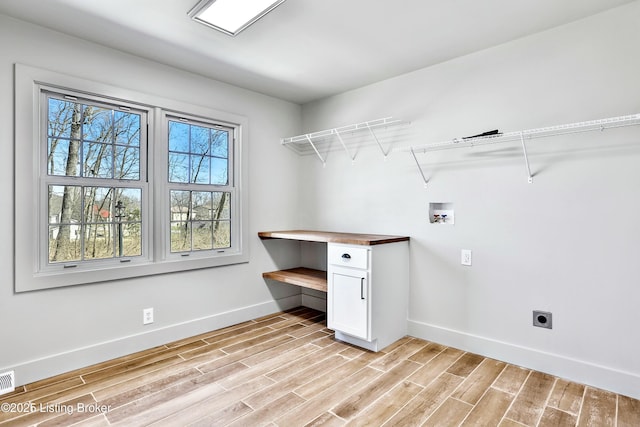 laundry area featuring washer hookup, visible vents, electric dryer hookup, light wood-type flooring, and baseboards