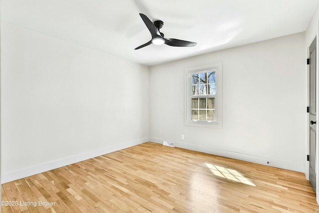 unfurnished room with a ceiling fan, baseboards, visible vents, and wood finished floors