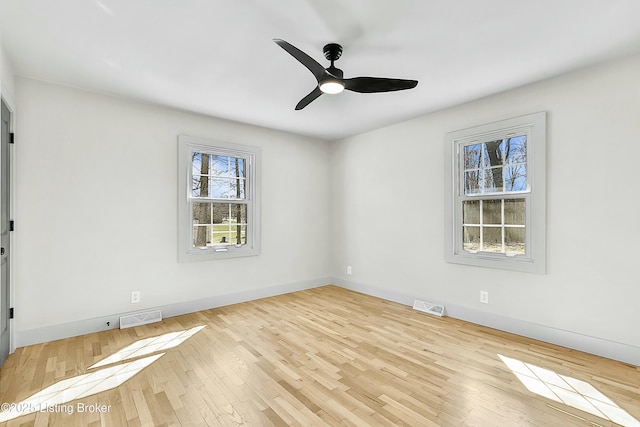 unfurnished room featuring ceiling fan, wood finished floors, visible vents, and baseboards