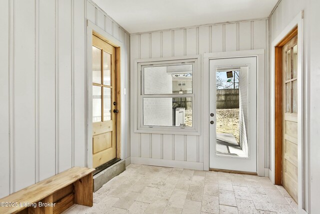 doorway with stone finish flooring and baseboards