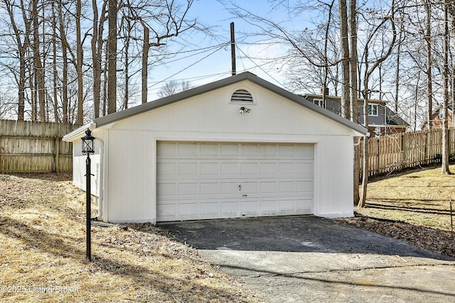 detached garage featuring fence