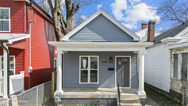 view of front of home featuring covered porch and fence