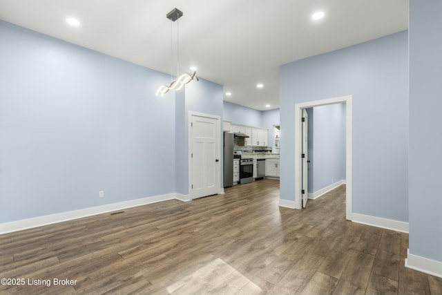 interior space with baseboards, dark wood-style flooring, and recessed lighting