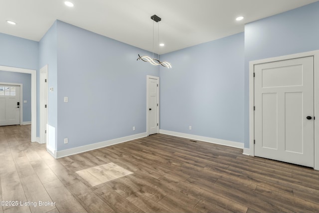 unfurnished dining area with recessed lighting, wood finished floors, and baseboards