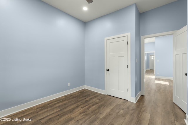 unfurnished room with a ceiling fan, recessed lighting, dark wood-style flooring, and baseboards