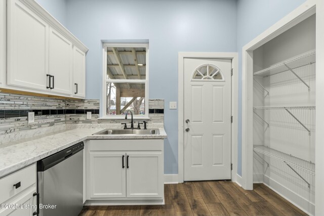 kitchen with a sink, white cabinets, light stone countertops, dishwasher, and dark wood finished floors