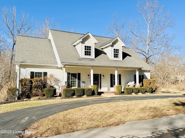 cape cod home featuring a porch