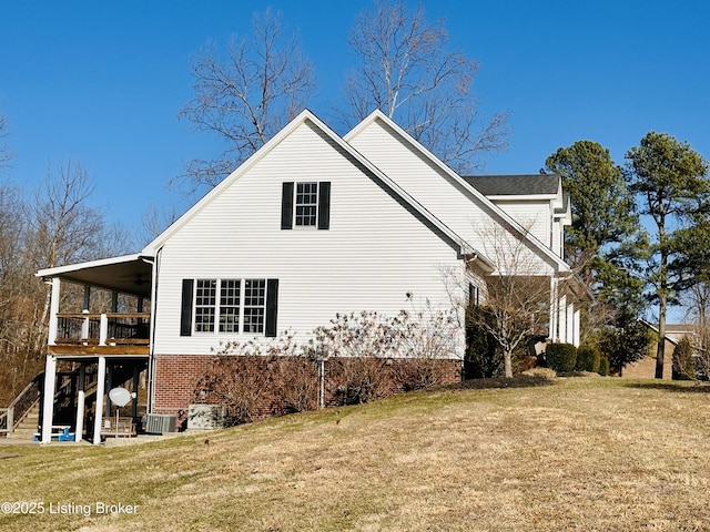 view of home's exterior featuring ceiling fan, stairs, and a yard