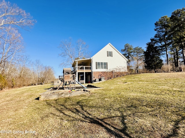 rear view of property with a lawn and a playground