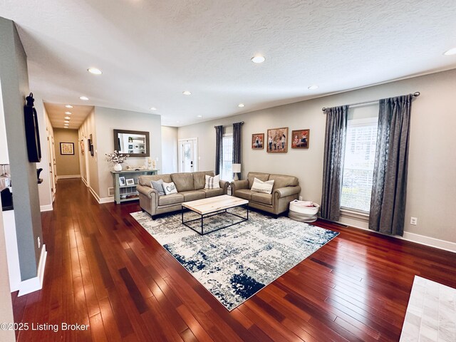 living area featuring dark wood-style floors, recessed lighting, a textured ceiling, and baseboards