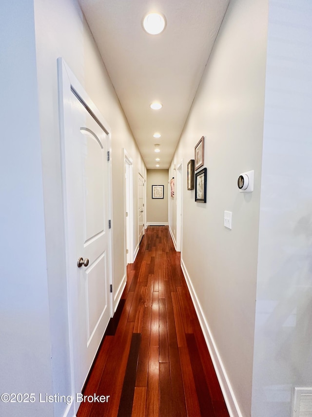 hallway featuring dark wood-type flooring, recessed lighting, and baseboards