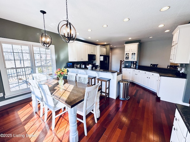 dining space with dark wood-style floors, recessed lighting, and an inviting chandelier