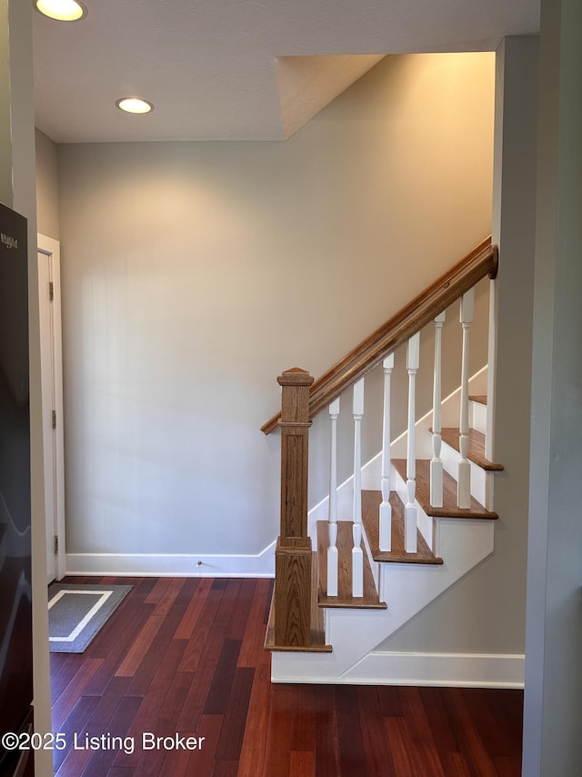 stairway featuring recessed lighting, wood finished floors, and baseboards