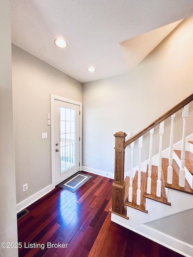 foyer featuring stairs, wood finished floors, visible vents, and baseboards