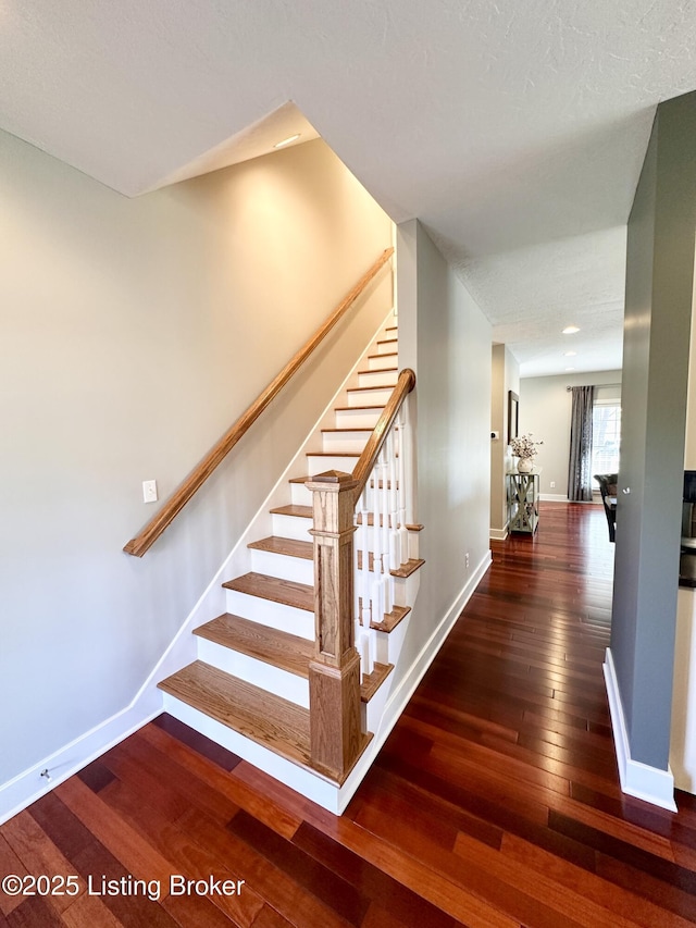 staircase featuring wood-type flooring and baseboards