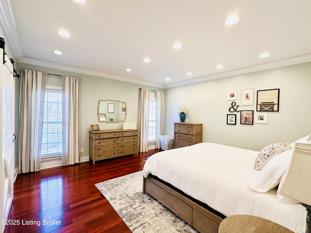 bedroom with dark wood finished floors, recessed lighting, a barn door, ornamental molding, and baseboards