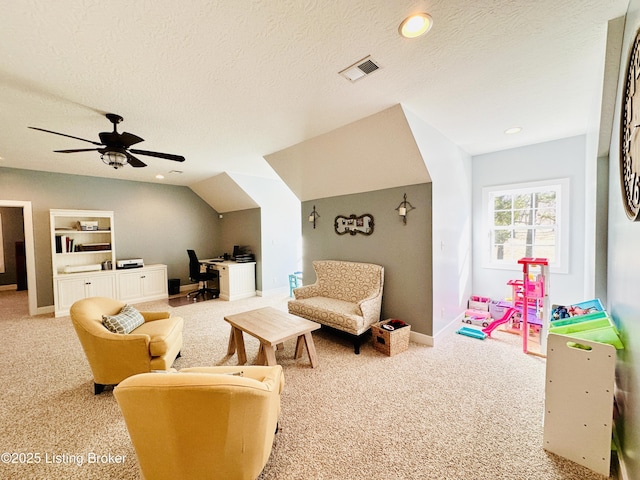 interior space with a ceiling fan, visible vents, a textured ceiling, and light colored carpet