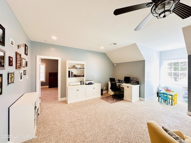 office area featuring a textured ceiling, ceiling fan, baseboards, and light colored carpet