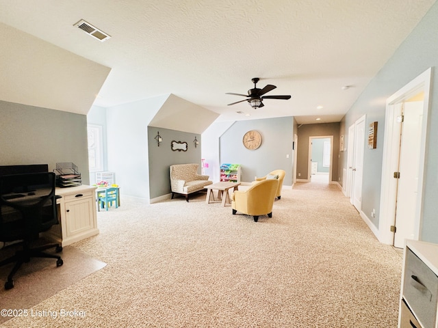 home office featuring light colored carpet, visible vents, and a textured ceiling