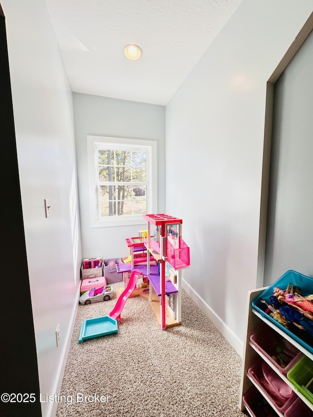 rec room featuring baseboards and carpet flooring