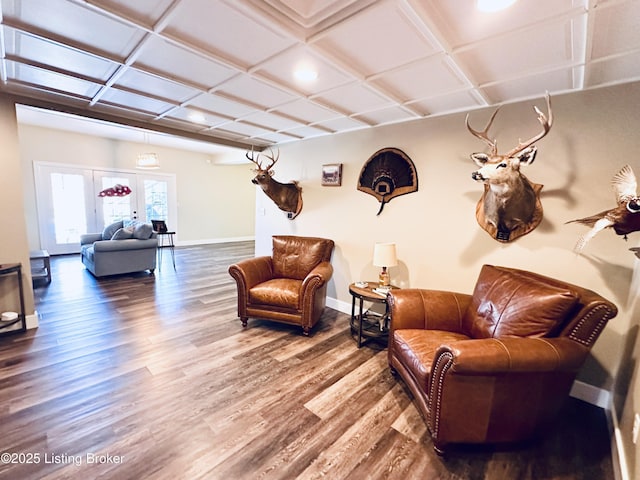 sitting room with baseboards, coffered ceiling, and wood finished floors