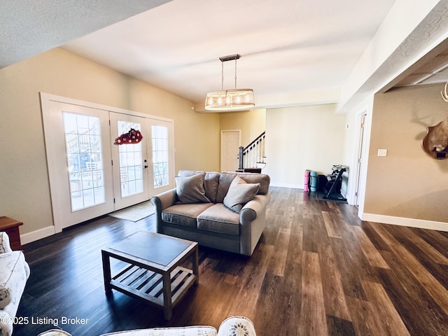 living room with dark wood-style floors, baseboards, and stairs