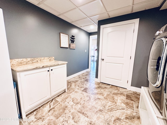 laundry area featuring cabinet space and baseboards