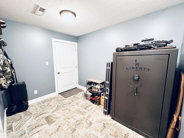 miscellaneous room featuring a textured ceiling, visible vents, and baseboards