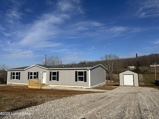 manufactured / mobile home featuring driveway, a detached garage, crawl space, a storage unit, and an outdoor structure