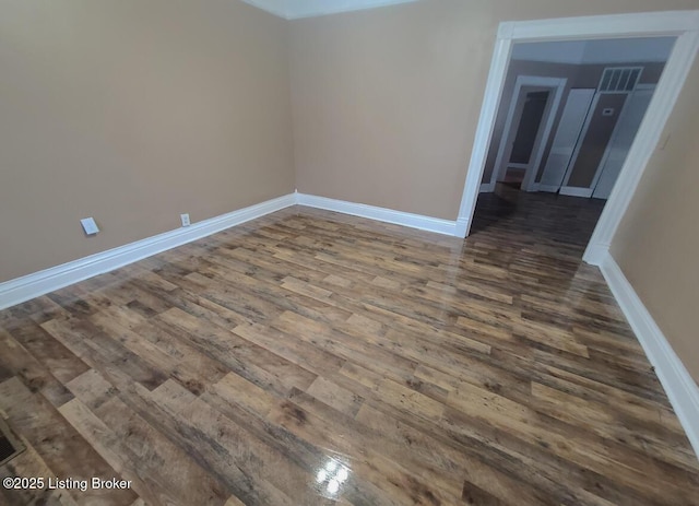 unfurnished room with dark wood-type flooring and baseboards