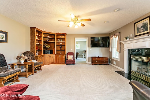 living area with a textured ceiling, baseboards, a fireplace, and light colored carpet