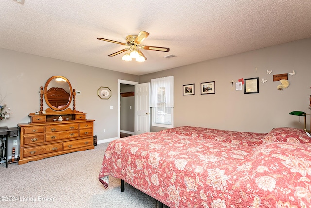 bedroom featuring a textured ceiling, carpet, visible vents, and baseboards