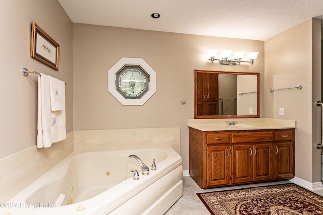 bathroom featuring a jetted tub, baseboards, a textured ceiling, and vanity