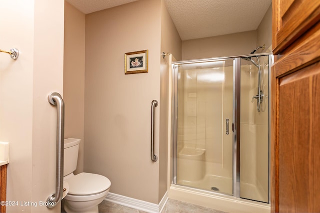 full bath with a textured ceiling, a stall shower, and toilet