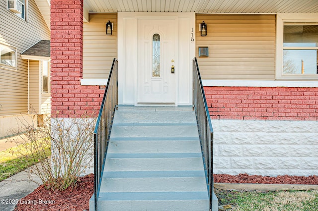 entrance to property featuring brick siding