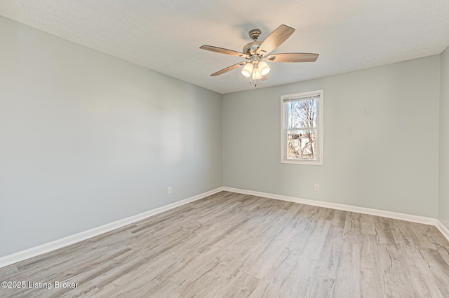 unfurnished room with light wood-type flooring, ceiling fan, a textured ceiling, and baseboards