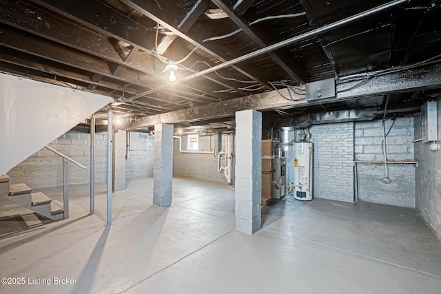 basement featuring electric panel, stairway, and gas water heater