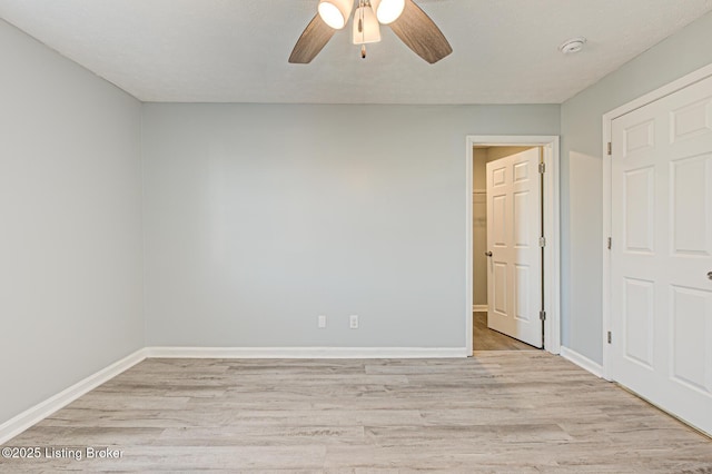 unfurnished bedroom with baseboards, a ceiling fan, and light wood-style floors